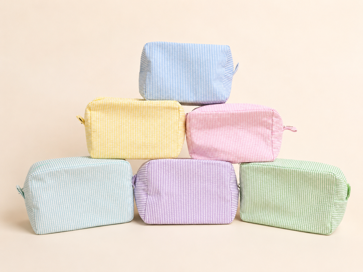Set of colorful striped toiletry bags on a beige background