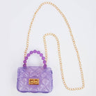 Purple handbag with a gold chain strap on a light gray background