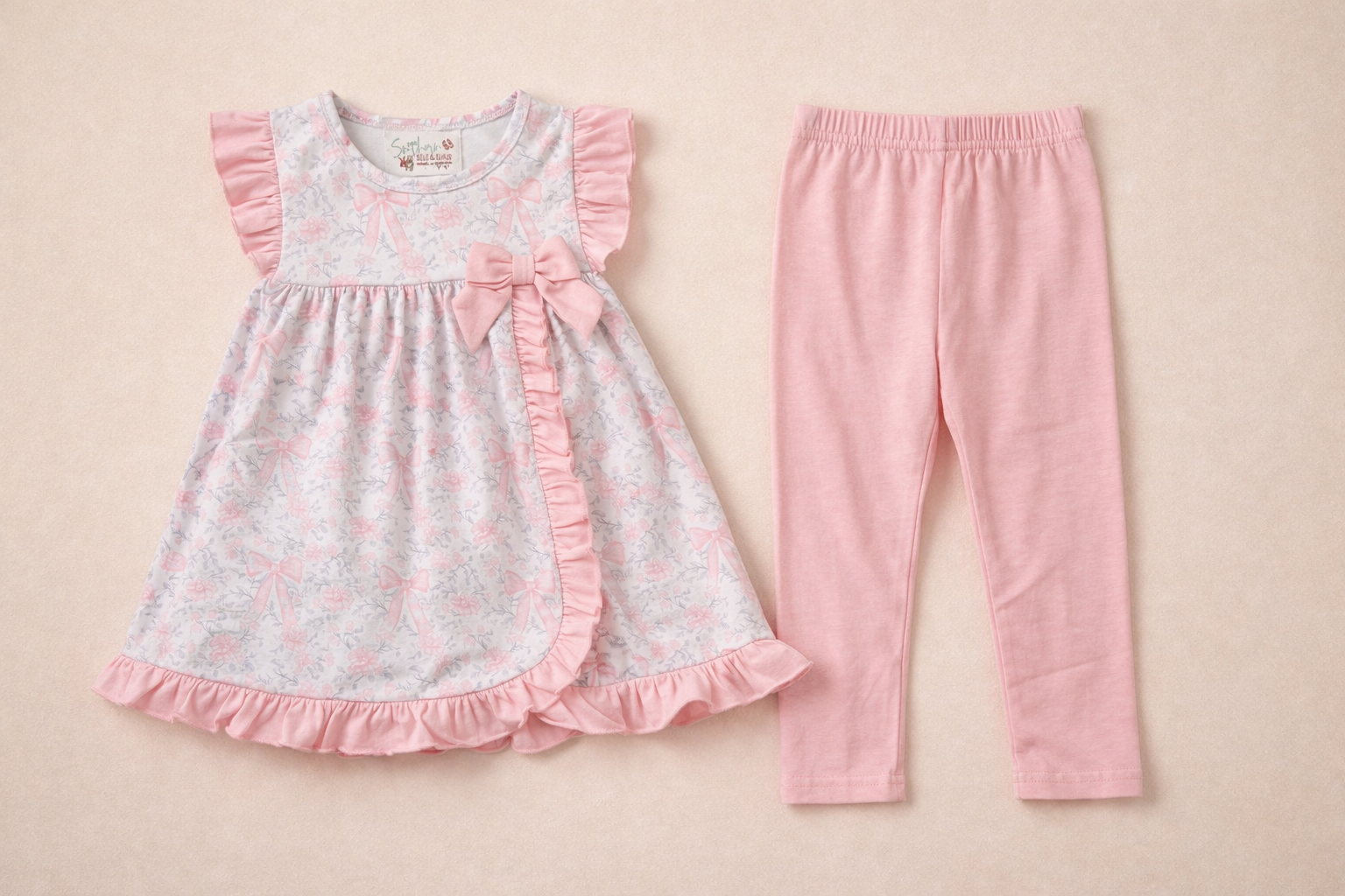 Floral top with ruffles and pink leggings on a beige background