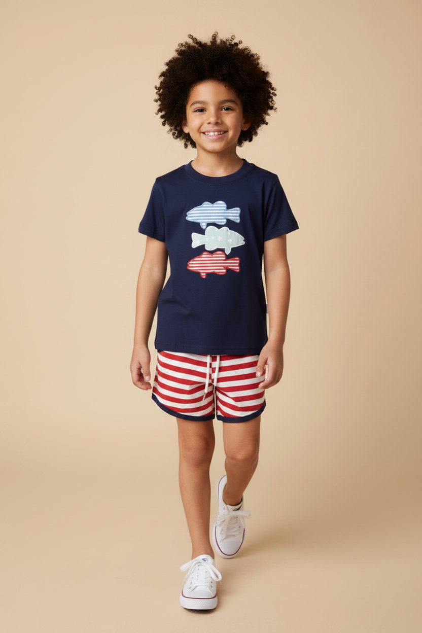 Boy model wearing a patriotic 3 fish navy shirt with red and white shorts. 