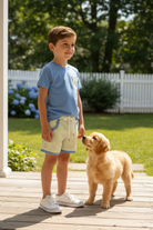 Boy standing on porch with puppy