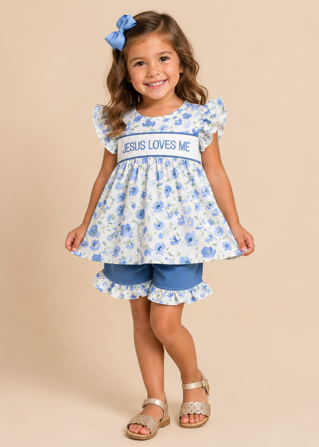 Young girl wearing a floral dress with 'Jesus Loves Me' text on a beige background