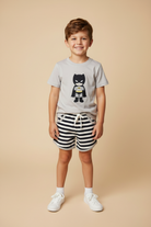 Young boy wearing a grey shirt with an embroidered character with black and white striped shorts.