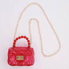 Pink handbag with red beads and gold chain on a white background