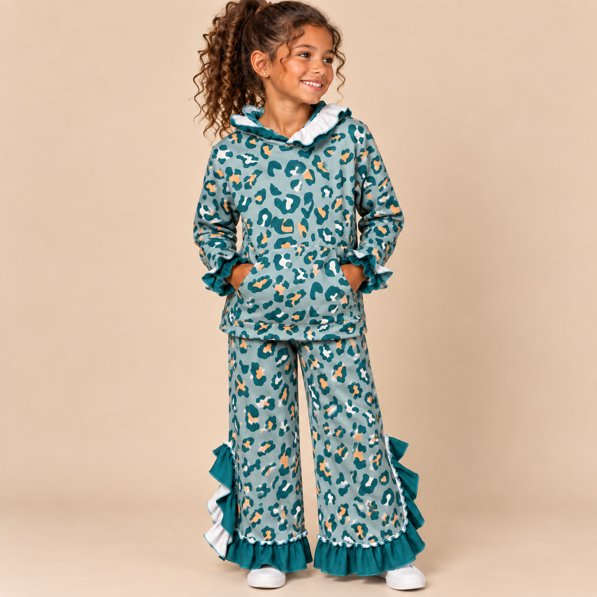 Young girl model wearing a dusty teal leopard print set trimmed in teal ruffles.