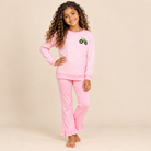 Young girl wearing a pink and white striped long sleeve shirt with pink ruffle flare pants. 