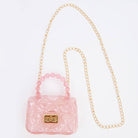 Pink handbag with a gold chain strap on a white background