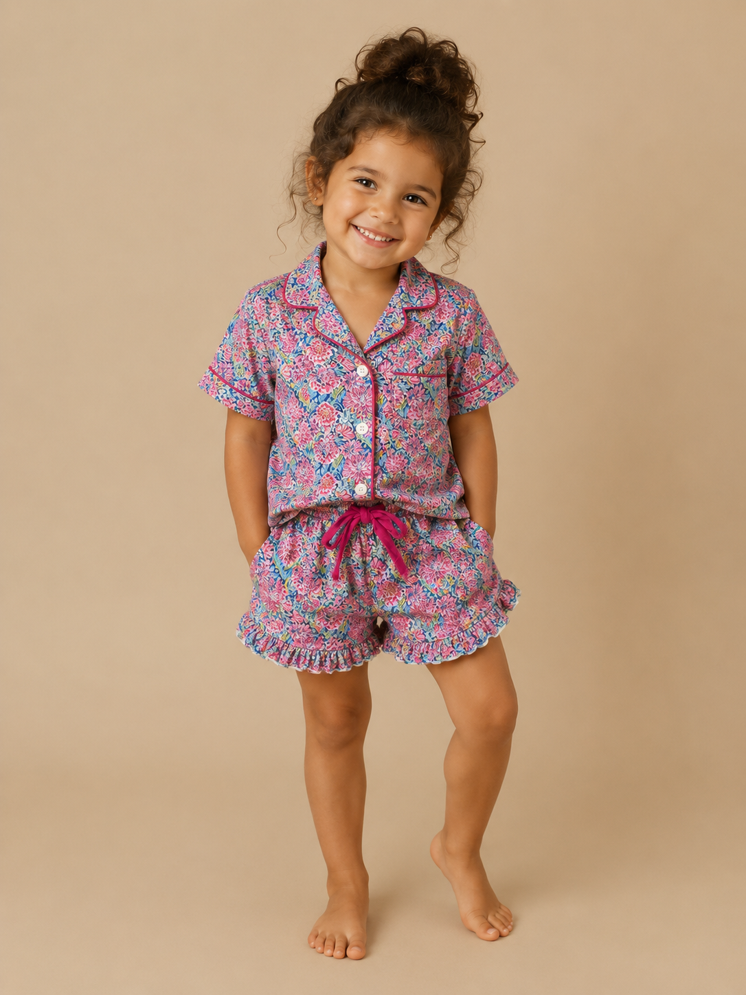 Child wearing a pink floral pajama set on a beige background
