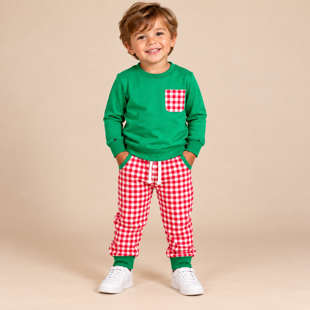 Toddler boy wearing a long sleeve green shirt and red & white gingham pants.