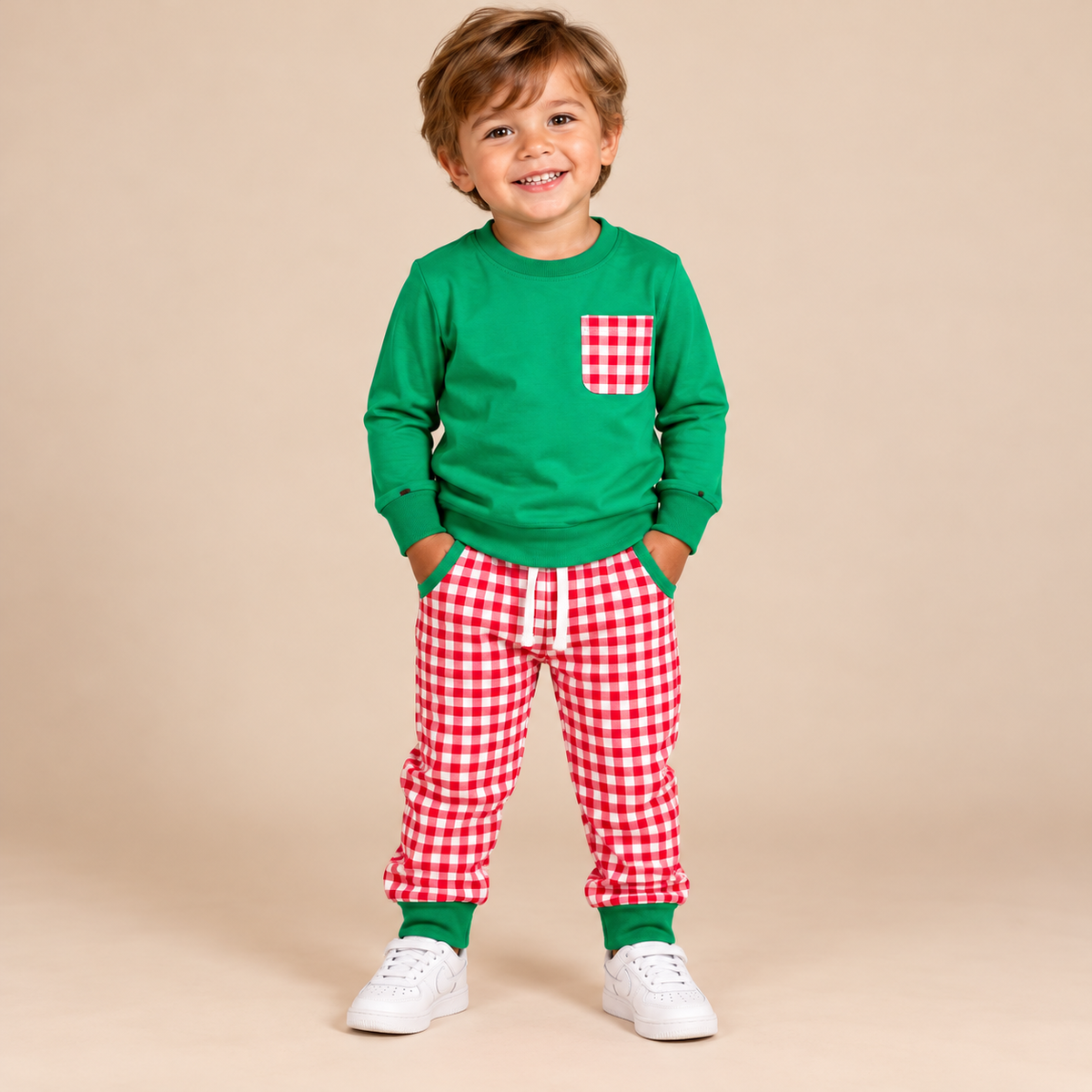 Toddler boy wearing a long sleeve green shirt and red & white gingham pants.