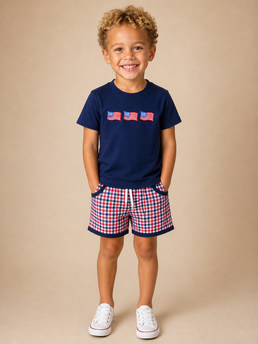 Boy wearing a navy shirt with flags on the front and plaid shorts