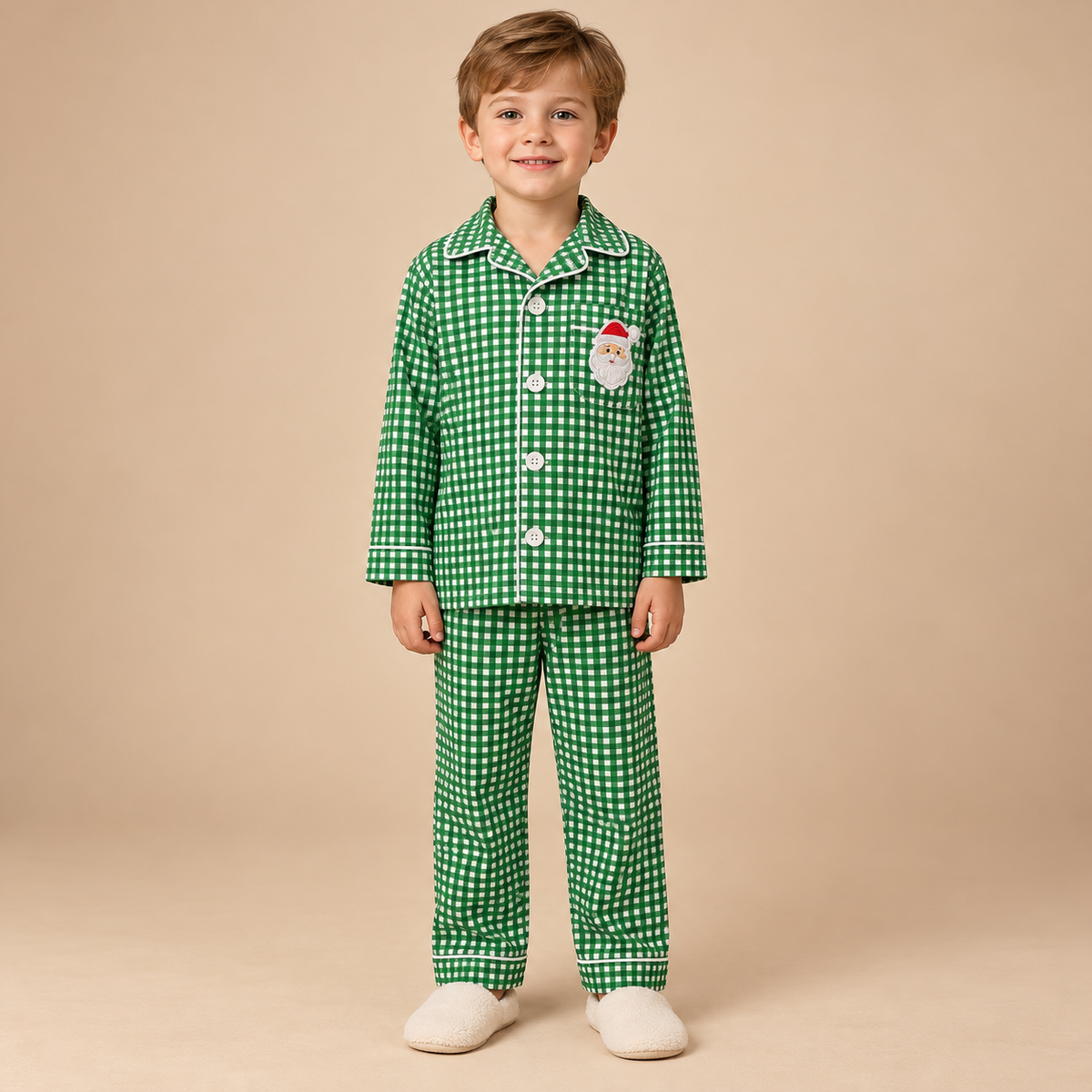 Young boy wearing green and white gingham lounge set with a santa applique. 