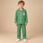 Young boy wearing green and white gingham lounge set with a santa applique. 