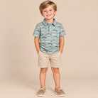 A toddler boy wearing a fish print collared polo.