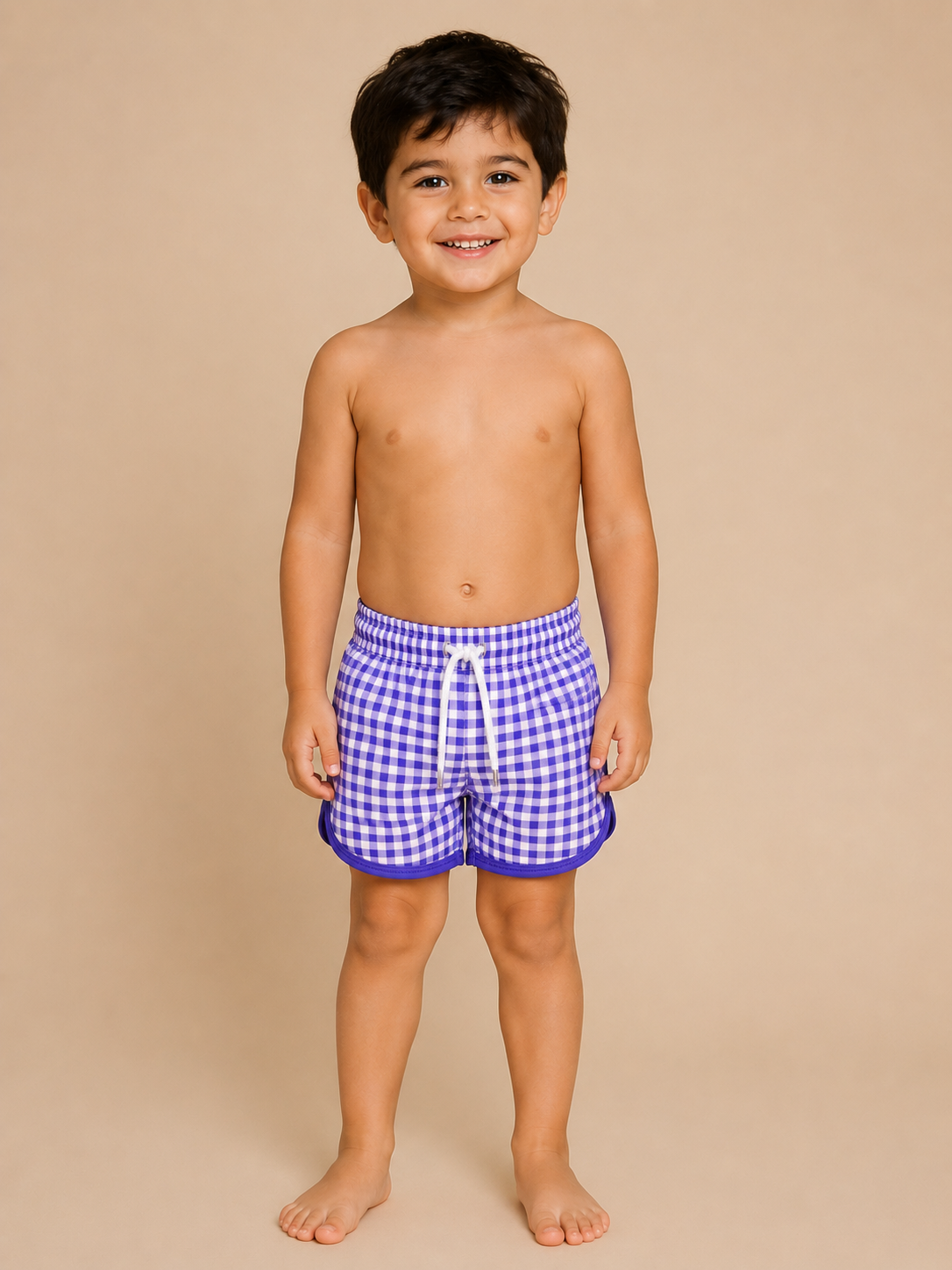 Child wearing blue checkered swim shorts on a beige background