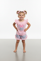 Girl wearing pink flutter sleeve Minnie applique top and floral ruffle shorts