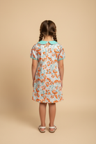 Back view of girl wearing Sweet Clementine Dress on beige background