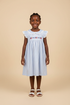 Girl wearing Liberty Lace Dress on beige background