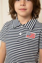 Close-up of American flag patch on navy stripe boys polo shirt