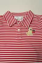 Close-up of embroidered golden retriever holding American flag on red stripe boys polo