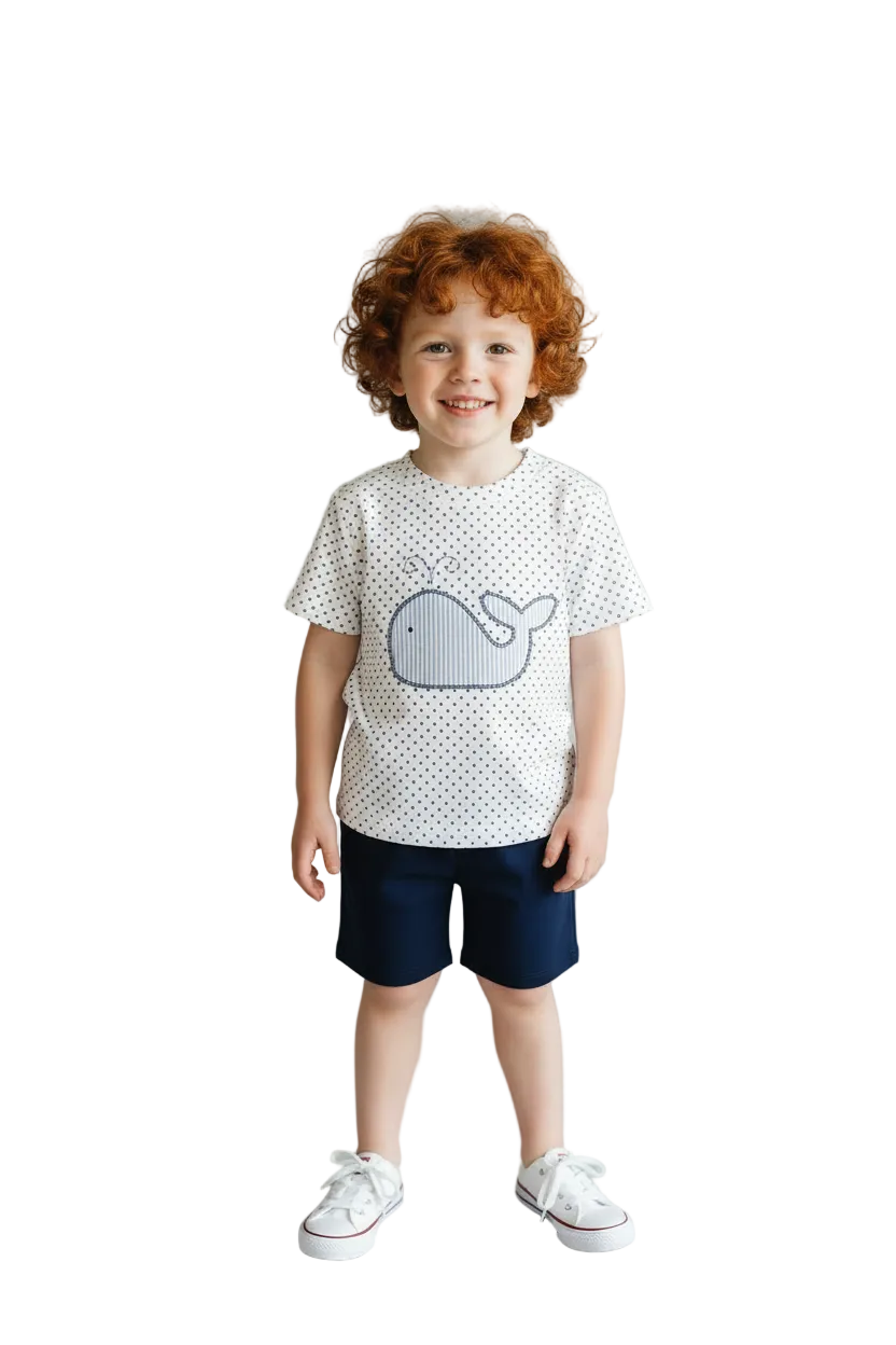 Toddler boy wearing a whale embroidered whale shirt and navy shorts. 
