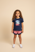 Girl model wearing navy blue shirt with patriotic fish.