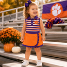 Girl wearing orange and purple stripe mascot skort set at Clemson stadium