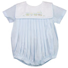 Baby romper with pleated skirt and embroidered design on a white background