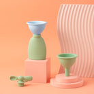 Set of silicone funnels
 on pink and peach-colored stands with a pink textured vase in the background.