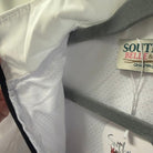 Close-up of a white children's jacket with a gray hood lining and a visible Southern Belle & Beauz brand tag.